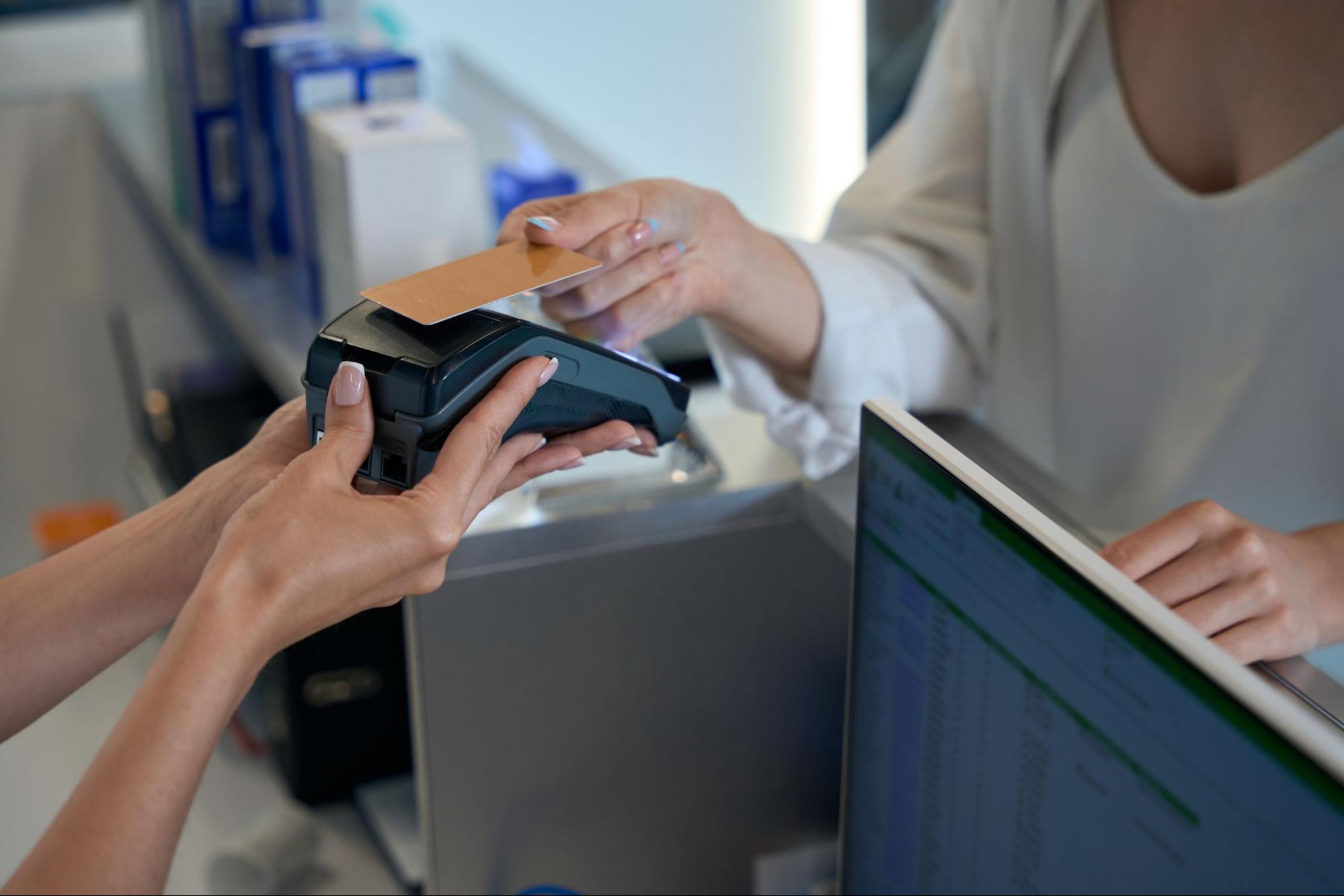 A Person Holding A Payment Terminal While Another Person Taps A Credit Card | Condor PH